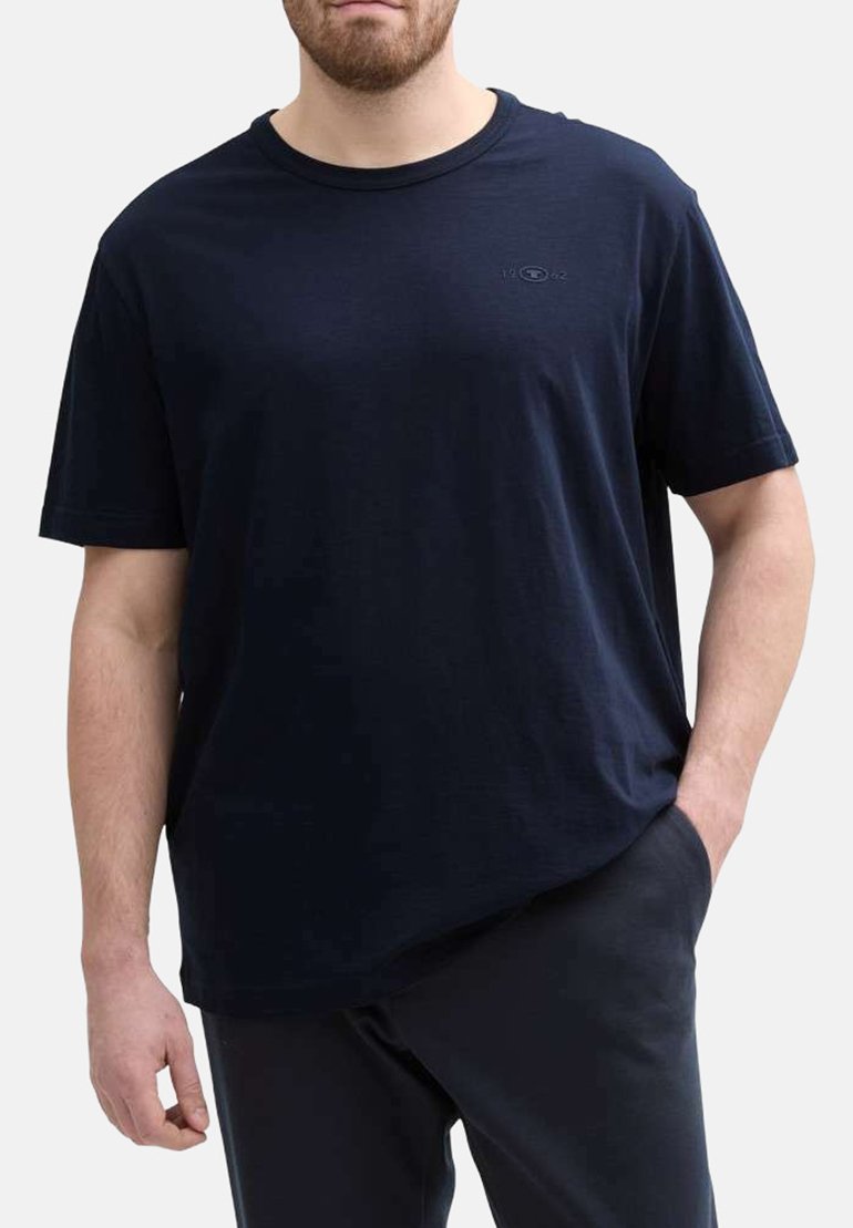 T-shirt bleu marine à manches courtes avec un col rond, en tissu doux, arborant un petit logo sur la poitrine et une coupe décontractée.