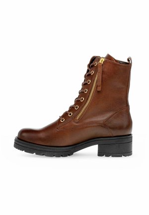 Brauner Lederknöchelstiefel mit seitlichem goldenem Reißverschluss, vorderen Schnürsenkeln, schwarzer grober Sohle und niedrigem Blockabsatz.
