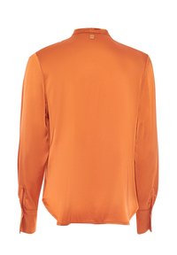 Camicia arancione a maniche lunghe con una texture liscia, colletto a sorreggere e polsini con bottoni. Presenta un'etichetta nella parte posteriore del collo.