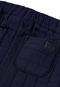 Pantalons bleu marine à taille élastique en tissu texturé, dotés d'une poche arrière et d'une petite étiquette noire sur la poche.