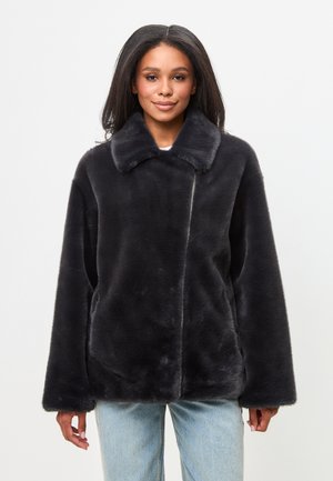Zwarte nepbont jas met een kraag, oversized pasvorm en zijzakken. Zachte textuur en een schone, minimalistische vormgeving.