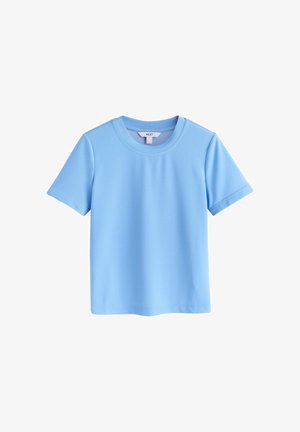 Világoskék, rövid ujjú, kerek nyakú póló fehér címkével a nyak belső oldalán, fehér háttéren.