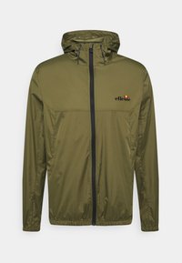Giacca con cappuccio di colore verde oliva, realizzata in tessuto leggero. Presenta una cerniera frontale, polsini elasticizzati e un piccolo logo stampato sul petto.