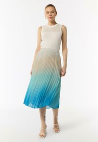 Gonna midi plissettata in gradiente dal beige chiaro al teal. Tessuto fluido, con una vita elasticizzata. Abbinata a un top aderente senza maniche bianco.