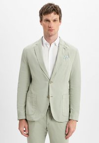 Hellgrüner, strukturierter Blazer mit zwei Brusttaschen, einem einzigen Knopfverschluss und einem dezenten gemusterten Taschentuch in der linken Brusttasche.