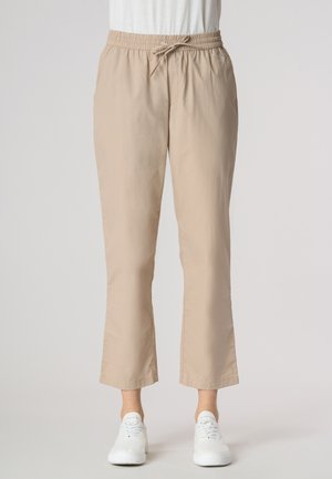 Pantaloni beige leggeri con vita elasticizzata e cordino. Lunghezza cropped, texture liscia con tasche laterali e una vestibilità rilassata.