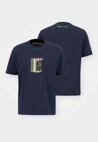 T-shirt de algodão azul-marinho com mangas curtas, apresentando um gráfico de bolso frontal com um balde de tinta listrado e texto de logotipo. Decote redondo.