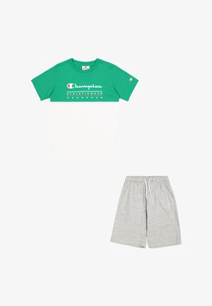 T-shirt Champion verde e bianco a maniche corte con logo, abbinato a pantaloni sportivi grigi con vita elastica e tasche.