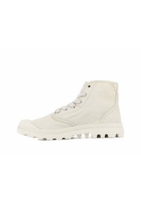 Zapatillas de lona de caña alta en un tono beige claro, con un upper texturizado, puntera redonda, diseño de cordones y una suela de goma blanca resistente.