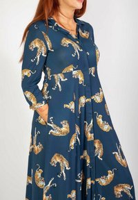 Langarmkleid aus navyblauem Stoff mit einem orange-weißen Tiger-Muster, mit Kragen, Knopfleiste und Seitentaschen.