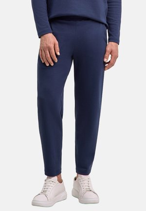 Dunkelblaue gerippte Jogginghose mit einem elastischen Bund, schmal zulaufenden Beinen und Seitennähten. Kombination mit weißen Sneakers für einen lässigen Look.