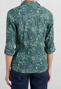 Camicia verde con stampa nautica di barche e bussole, realizzata in un tessuto testurizzato, con maniche arrotolabili e colletto classico.