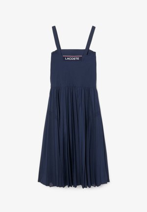 Vestido azul marino con tirantes delgados ajustables, un corsé entallado y una falda plisada con paneles de malla. Logo de Lacoste en el escote.