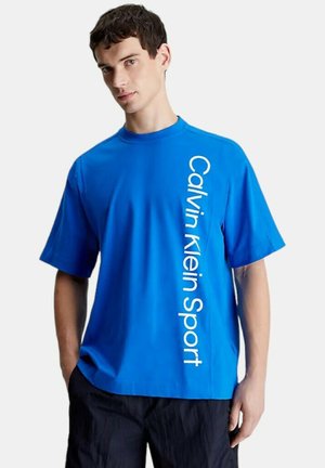 T-shirt blu a maniche corte realizzato in tessuto morbido, caratterizzato da una stampa verticale del logo bianco sul lato sinistro. Design con colletto a girocollo.