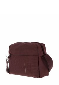 Sac messager en textile bordeaux avec une fermeture éclair, une poche latérale et une bandoulière réglable ; arbore un motif à pois et un détail de marque.