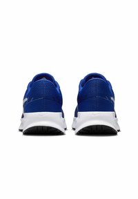 Niebieskie buty sportowe z oddychającą siateczkową cholewką, białą podeszwą i teksturowaną gumową podeszwą zewnętrzną. Zawierają branding Nike po bokach.