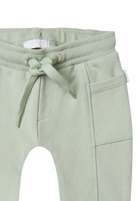 Lichtgroene joggingbroek van zachte katoen. Bevat een geribde tailleband, koordsluiting en zijzakken met een gladde textuur.