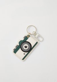 Keychain designed as a camera, featuring a white and green exterior, round black lens detail, circular hardware, and a metal keyring attachment.