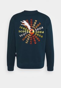 Felpa blu marina con un motivo a spirale colorato con il testo "Scotch" e "Soda" e una tigre bianca saltante ricamata sul retro.