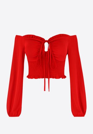 Haut court rouge à épaules dénudées avec manches longues bouffantes, devant froncé et fermeture à nouer. Caractérisé par un ourlet froncé et une texture lisse.