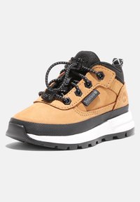 Světlé hnědé semišové tenisky s černými akcenty, texturovanou gumovou podrážkou, elastickými šnůrkami na bungee, zesílenou špičkou a logem Timberland.