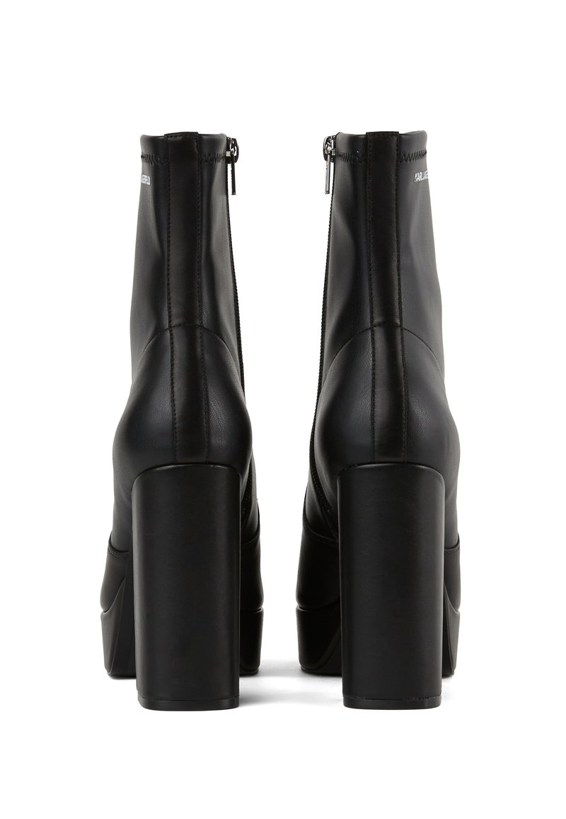 Zwarte leren enkelboots met een hoge blokhak, een slank ontwerp, een rits aan de achterkant en zichtbare stiksels.