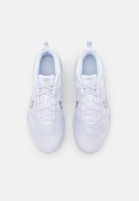 Scarpe sportive bianche con tomaia in rete, chiusura con lacci e logo swoosh argentato. Il design include un tassello sul tallone per una facile calzata.