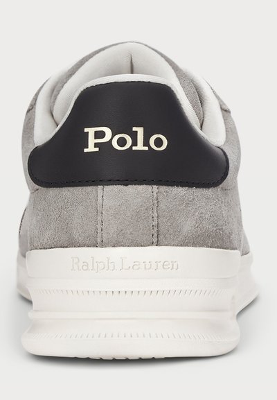 Πίσω όψη γκρι σουέτ αθλητικού παπουτσιού με λευκή σόλα, μαύρο ταμπελάκι στη φτέρνα που αναγράφει "Polo" και "Ralph Lauren" ανάγλυφο στη μεσοσόλα.
