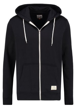Tamsiai mėlyna zip-up džemperis, pagamintas iš medvilnės ir sintetinių pluoštų mišinio. Nuo priekinės pusės turi kišenę, reguliuojamą kapucę, o užtrauktukas ir raišteliai yra kontrastingos baltos spalvos.