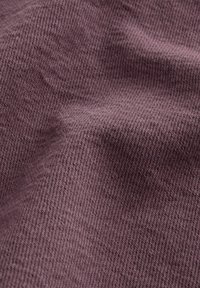 Tekstuirano platno u umirujućoj mauve boji, s dijagonalnim tkalačkim uzorkom, prikazuje blage nabore i sjene za dubinu.