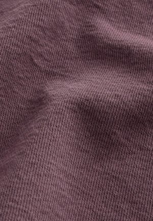 Texturovaná tkanina v tlumené barvě mauve, s diagonálním vzorem tkaní, vykazující jemné záhyby a stíny pro hloubku.