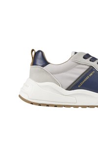 Sneaker blu e grigie con tomaia in materiali misti, caratterizzate da una suola bianca chunky e dettagli in oro con il logo sul lato.