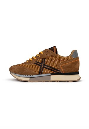 Zapatilla marrón y naranja con materiales de malla y ante, que presenta un diseño texturizado, acentos negros y una suela color crema.
