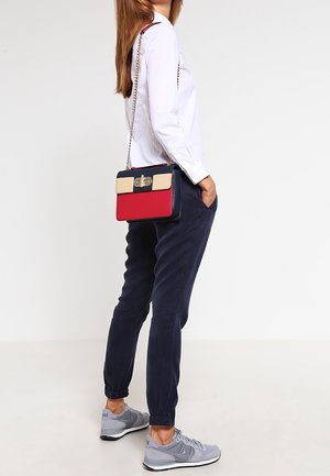 Torebka na ramię o usztywnionej formie w kolorach czerwonym, granatowym i beżowym. Posiada metalowe zapięcie, łańcuszkowy pasek oraz gładką strukturę.