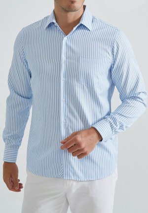 Chemise boutonnée rayée bleu clair et blanche, en coton, à manches longues, avec une poche sur la poitrine gauche, ourlet arrondi et col pointu.