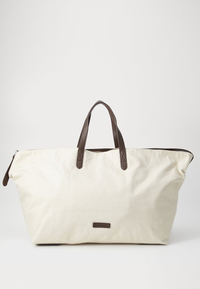 Grande borsa in tela beige con manici in pelle marrone e chiusura con cerniera. Presenta una forma rettangolare e un'etichetta del marchio discreta sul davanti.
