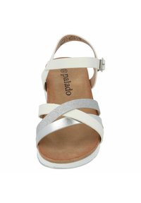 Sandal bianco con cinturini incrociati in finiture argento e opache. Presenta una soletta texturizzata e una cinghia alla caviglia regolabile in argento.