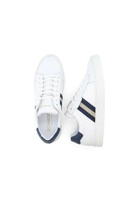 Baskets blanches avec des rayures bleu marine, lacets plats, semelle en caoutchouc texturée et logo doré. Tige en synthétique lisse avec des accents subtils.