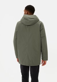 Groene, gevoerde jas met een gladde textuur, met een rechte snit en lange mouwen. De achterkant toont geen zichtbare hardware of patronen.