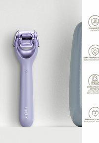 Lila ansiktsroller med ett texturerat, justerbart huvud. Slät handtag med en liten rund knapp och varumärket "GESKE" i vitt.