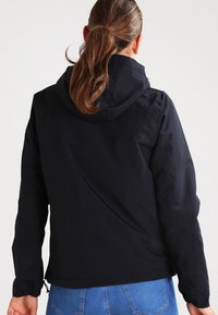 Sort vandtæt jakke med hætte, elastiske mansjetter og en afslappet pasform. Glat tekstur, ingen synlige mønstre. Har snoretræk i kanten.