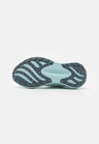 Merrell sportsko såle, med en lyseblå bunn og et teksturert svart gummimønster, samt preget merkeinnskrivning.