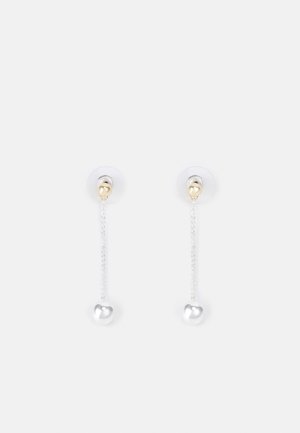Paire de boucles d'oreilles pendantes avec de petits clous en forme de cœur en or et de délicates chaînes en argent se terminant par des pendentifs en forme de cœur en argent.