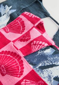 Baumwollstoff in Pink und Marineblau mit Muschelmotiven und einem karierten Muster. Die Textur ist weich mit sichtbaren Stickdetails.