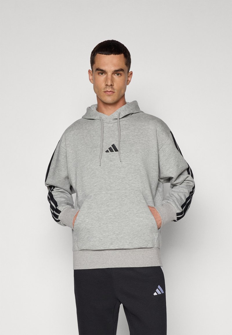 Sweatshirt cinza com capuz, bolso frontal, detalhes em preto com três riscas nas mangas e pequeno logotipo preto no peito.