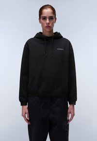 Zwarte hoodie gemaakt van een katoenmix, met een trekkoordcapuchon, geribbelde manchetten en een klein logo op de borst, gedragen met donkere broek.