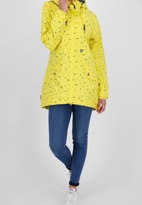 Gul vandtæt jakke med mønster af små både, med frontlynlås, to sidelommer og justerbar snøre i hætten.