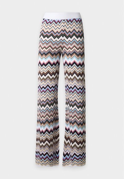 Pantalon en maille évasé avec un motif zigzag multicolore en blanc, beige, noir, bleu, rose et marron avec une ceinture blanche unie.