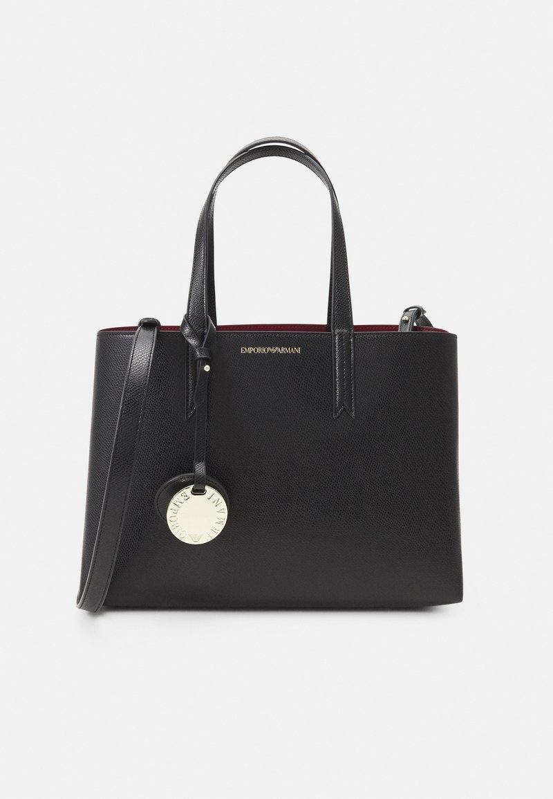 Musta teksturoitu nahkatote-laukku, jossa on kaksinkertaiset kahvat, irrotettava olkahihna, kullanvärinen Emporio Armani logo ja pyöreä kullanvärinen charm etupuolella.