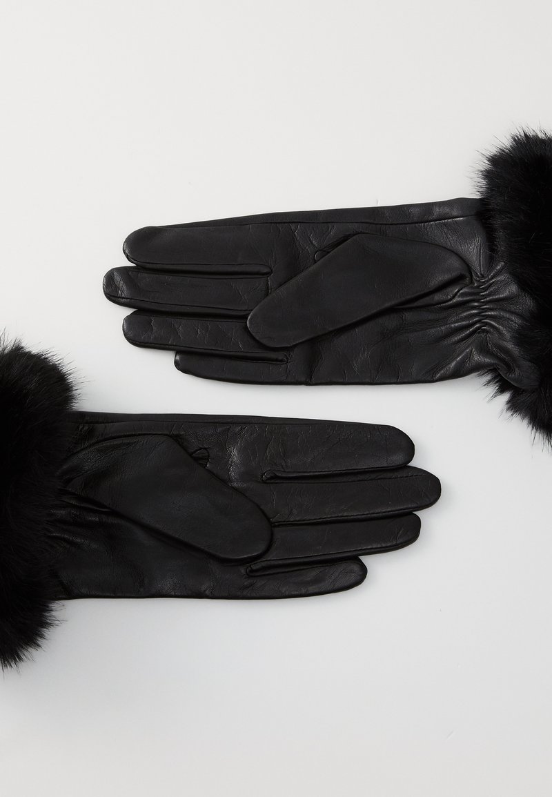 Schwarze Lederhandschuhe mit einem weichen schwarzen Fellbund, die eine glatte Textur, eine enganliegende Passform und einen leichten Glanz auf der Lederoberfläche aufweisen.
